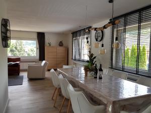 格罗尔斯泰因Dolce Vita Gerolstein -Dani的一间设有大桌子和白色椅子的用餐室