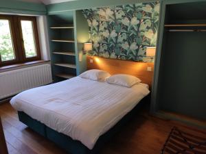 拉罗什-阿登Villa Le Genêt Fleuri的一间卧室设有一张大床和花卉墙