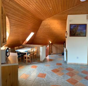 鲍洛通塞迈什House4U的厨房以及带桌子和木制天花板的用餐室。
