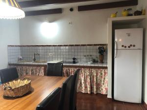 GuarazocaCASA RURAL BUENAVISTA的厨房配有桌子和白色冰箱。