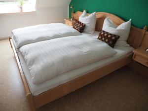 Nahrendorf梅耶旅馆的一张配有白色床单和枕头的大床
