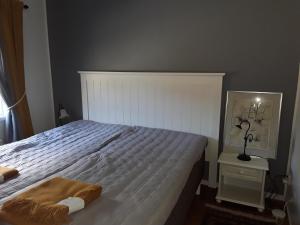 韦斯特罗斯The Cottage Badelunda的卧室配有一张白色的床,床上有毯子