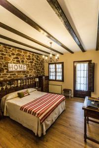 洛斯科拉莱斯-德布埃尔纳皇家曼塔内萨乡村民宿的一间卧室设有一张床和石墙