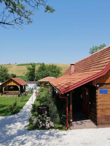 克拉皮纳Pod orehom drvena kuća i sauna的一座红色屋顶的建筑和一个鲜花庭院