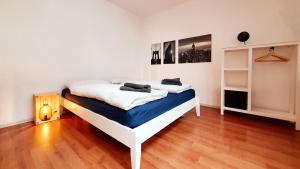 比勒费尔德Zentrales Dachgeschoss-Apartment Bielefeld的铺有木地板的客房内的一张白色床