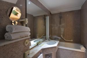 阿西西冯特贝拉酒店的一间带水槽、浴缸和镜子的浴室