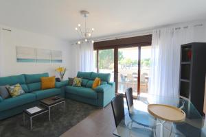 维拉摩拉Monte Laguna - Clever Details的客厅配有蓝色的沙发和桌子
