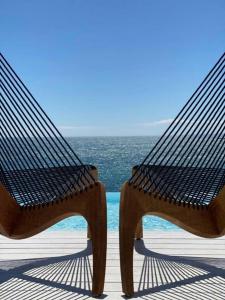 莫诺波利贝拉维斯塔套房住宿加早餐旅馆的坐在靠近海洋的甲板上的长凳