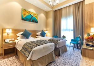 迪拜Rose Plaza Hotel Al Barsha的酒店客房设有两张床和窗户。