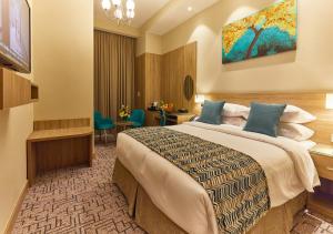 迪拜Rose Plaza Hotel Al Barsha的配有一张床和一张书桌的酒店客房