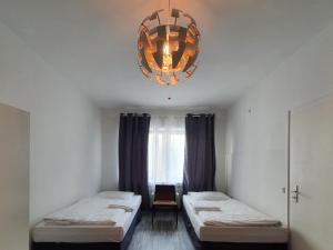 杜塞尔多夫Aparthouse Graf-Adolf的客房设有两张床和吊灯。