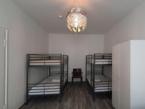 杜塞尔多夫Aparthouse Graf-Adolf的客房设有三张双层床和吊灯。