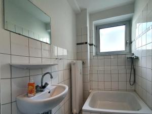 杜塞尔多夫Aparthouse Graf-Adolf的一间带水槽、浴缸和镜子的浴室