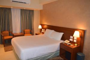 明亚Omar El Khayam Al Minya Hotel的酒店客房配有一张床和电话
