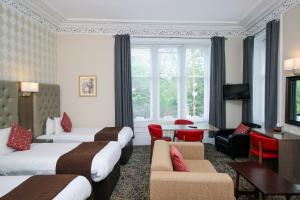 格拉斯哥阿尔比欧酒店的酒店客房带两张床和一张桌子以及椅子。