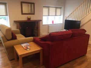 约克The Annexe - Acomb Green的客厅配有红色的沙发和桌子
