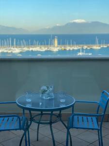 代森扎诺-德尔加达Molino Apartments的阳台上配有带玻璃杯的桌子和两把椅子