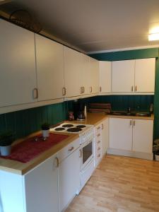 艾菲约德Kvamsdal Pensjonat的厨房配有白色橱柜和炉灶烤箱。
