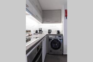 雅典Brand New Aprt with backyard in Lycabettus Hill !的厨房配有洗衣机和洗衣机。