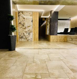 克拉科夫JJ Sport Concept Hotel的大堂,在大楼内铺有石质瓷砖地板