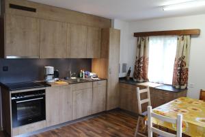 萨斯格伦德Haus Weideli, Dammstrasse 7的厨房配有木制橱柜、水槽和桌子