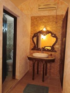 乌姆苏克Nouveau Bungalow Djerba的一间带水槽和镜子的浴室