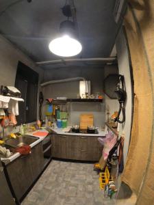 玉里镇途中玉里青年旅舍On My Way Yuli Hostel的一间带水槽和炉灶的小厨房