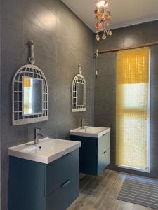 阿夏尔奇亚Ash Villa的浴室设有2个水槽、镜子和窗户。