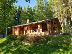 VihtavuoriKuhajärven Suviranta cottage的树林中的山丘上的小木屋