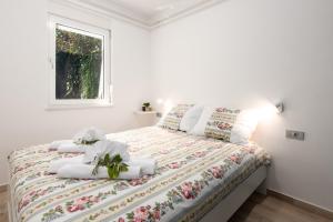 奥帕提亚Apartment Majda Opatija的一间卧室配有一张带白色床单的床和一扇窗户。