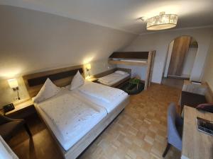 OberteuringenHotel & Restaurant "Am Obstgarten"的卧室配有一张白色大床和一张书桌