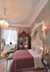 科尔马Castelnau的一间卧室配有一张大床和一个吊灯。