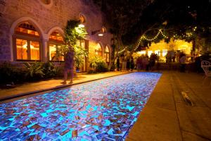贝鲁特Arthaus Beirut的一条在晚上街上有灯光游泳池的走道