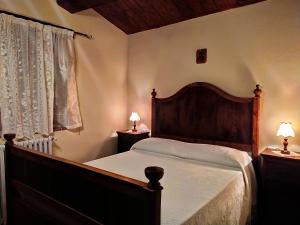 Molino AbbadiaFrigino Agriturismo的一间卧室配有一张床和两张台灯。