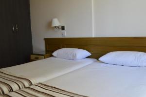 尼科西亚尼科西亚罗德斯公寓式酒店的两张带白色枕头的床,彼此相邻