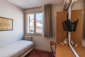图卢兹奥尔斯布兰科酒店的客房设有床、电视和窗户。