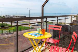 鲁瓦扬Best Western Hôtel Royan Océan的海滩景阳台配有桌椅