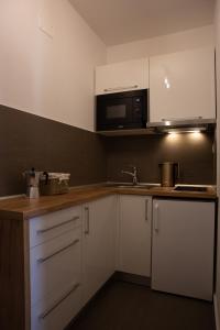 贝谢诺瓦Apartmán Dagmar的厨房配有白色橱柜和微波炉