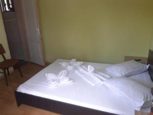 苏利纳Delta ca Odinioara的一张铺有白色床单的床铺,床上有白色的鲜花
