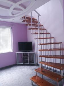 奥布佐尔Sania的客房设有螺旋楼梯和电视。