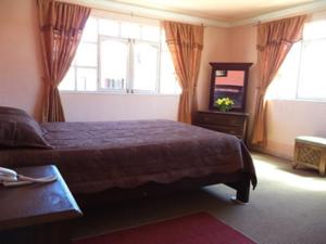 波托西图克萨阿帕特酒店的卧室配有床、镜子和窗户。