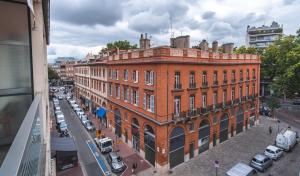 图卢兹奥尔斯布兰科酒店的城市街道上一座大型红砖建筑
