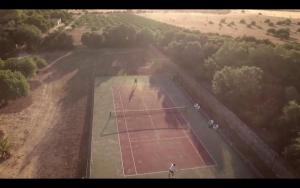 坎皮卡福特卡萨尔圣欧拉利娅酒店的网球场的空中景观,上面有一个人