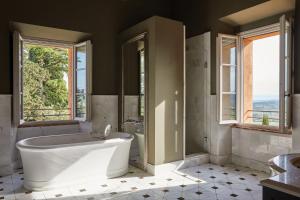 卡索莱德尔萨Castello di Casole, A Belmond Hotel, Tuscany的带浴缸和卫生间的浴室以及窗户。