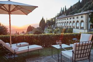 菲耶索莱Villa San Michele, A Belmond Hotel, Florence的桌椅、雨伞和建筑