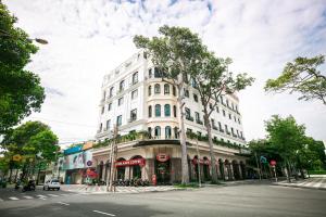 头顿Kim Minh Apartment & Hotel的街道拐角处的白色建筑