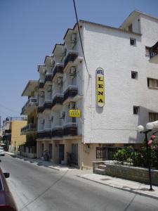 萨索斯Hotel Lena的建筑的侧面有黄色标志