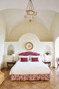 拉维罗Caruso, A Belmond Hotel, Amalfi Coast的卧室配有一张带吊灯的大型白色床。