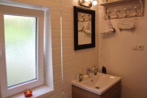 锡比乌La Bella的一间带水槽和镜子的浴室以及窗户。