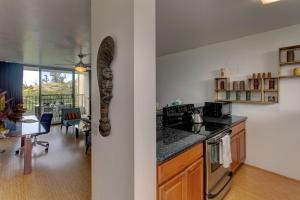 希洛Mauna Loa Shores #405 condo的一间带炉灶的厨房和一间带桌子的用餐室